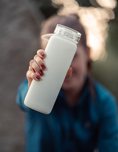 Woman holding a bottle with mBIOTA's Elemental Diet solution